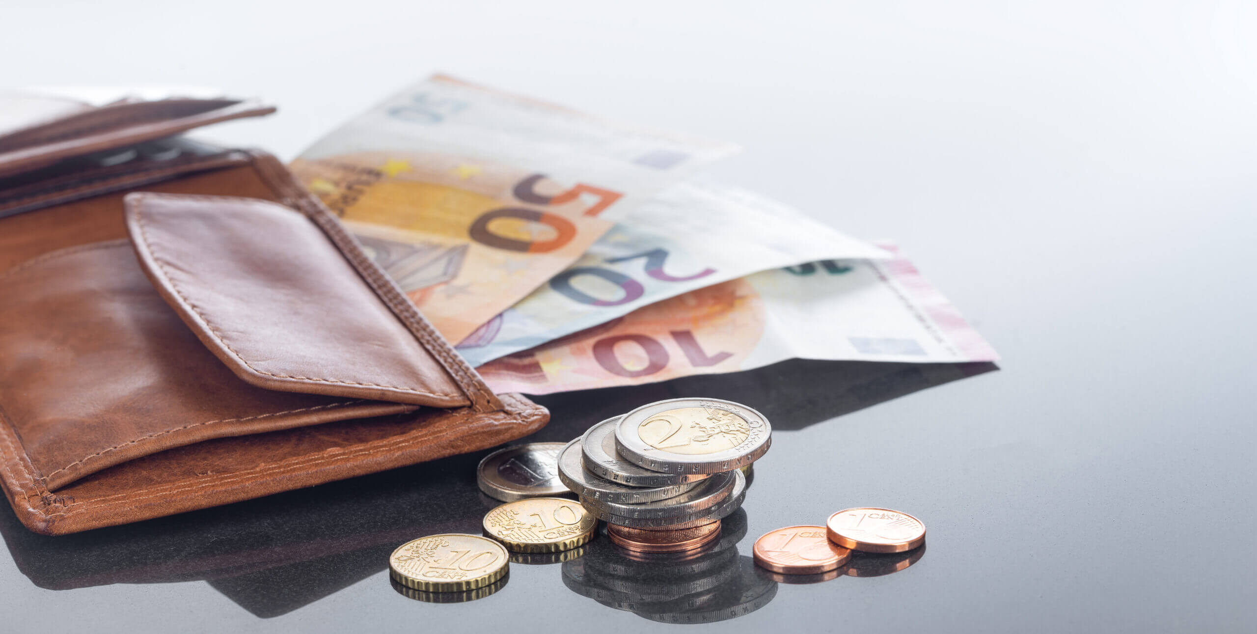 Finanzen, Geldbörse und Eurobargeld auf spiegelndem Tisch, Hintergrund
